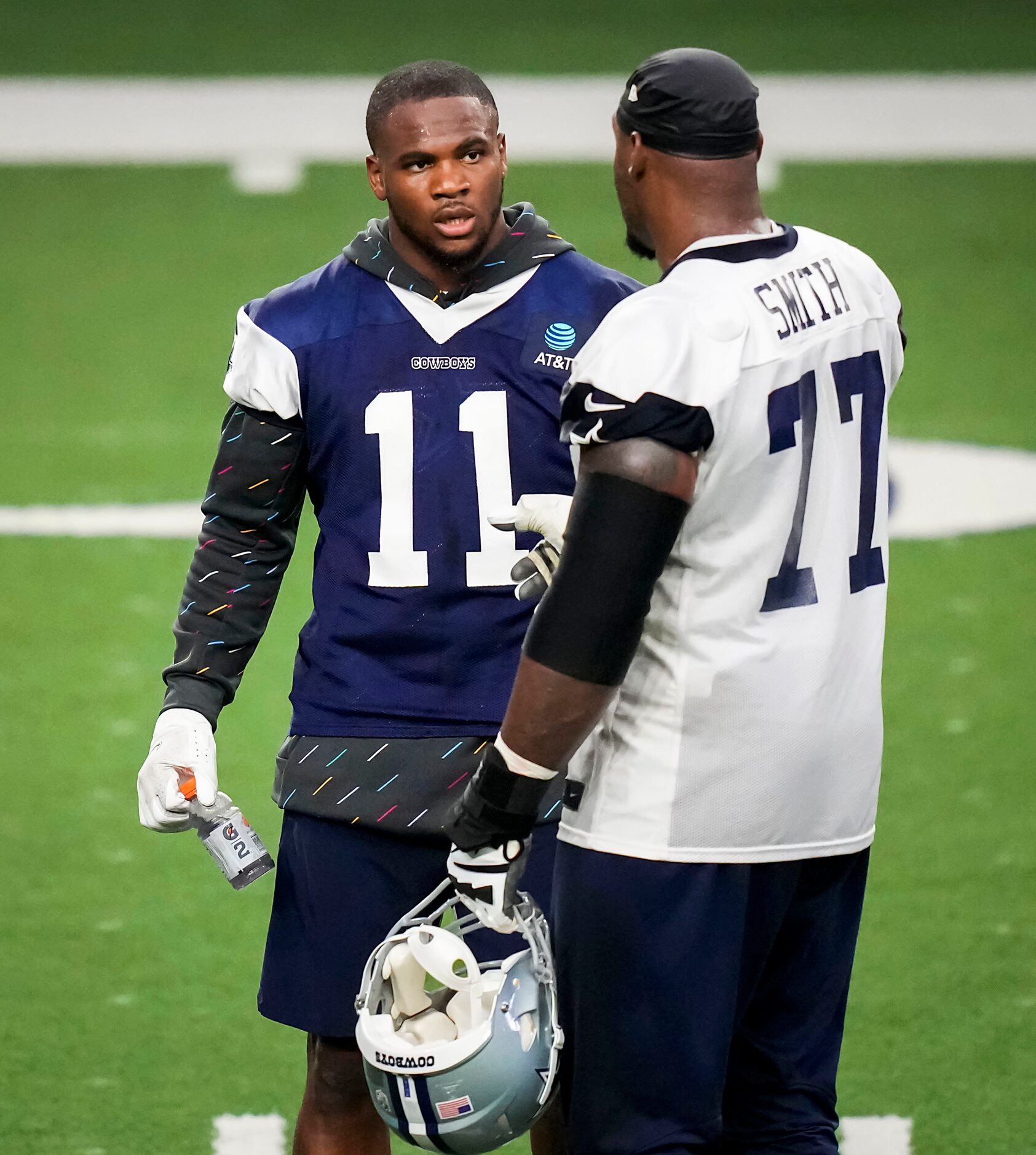 Dallas Cowboys linebacker Micah Parsons (11) talks with tackle Tyron Smith (77) during the...