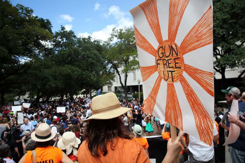 A protestor carries a sign calling for a "Gun Free UT", as they join others during a protest...