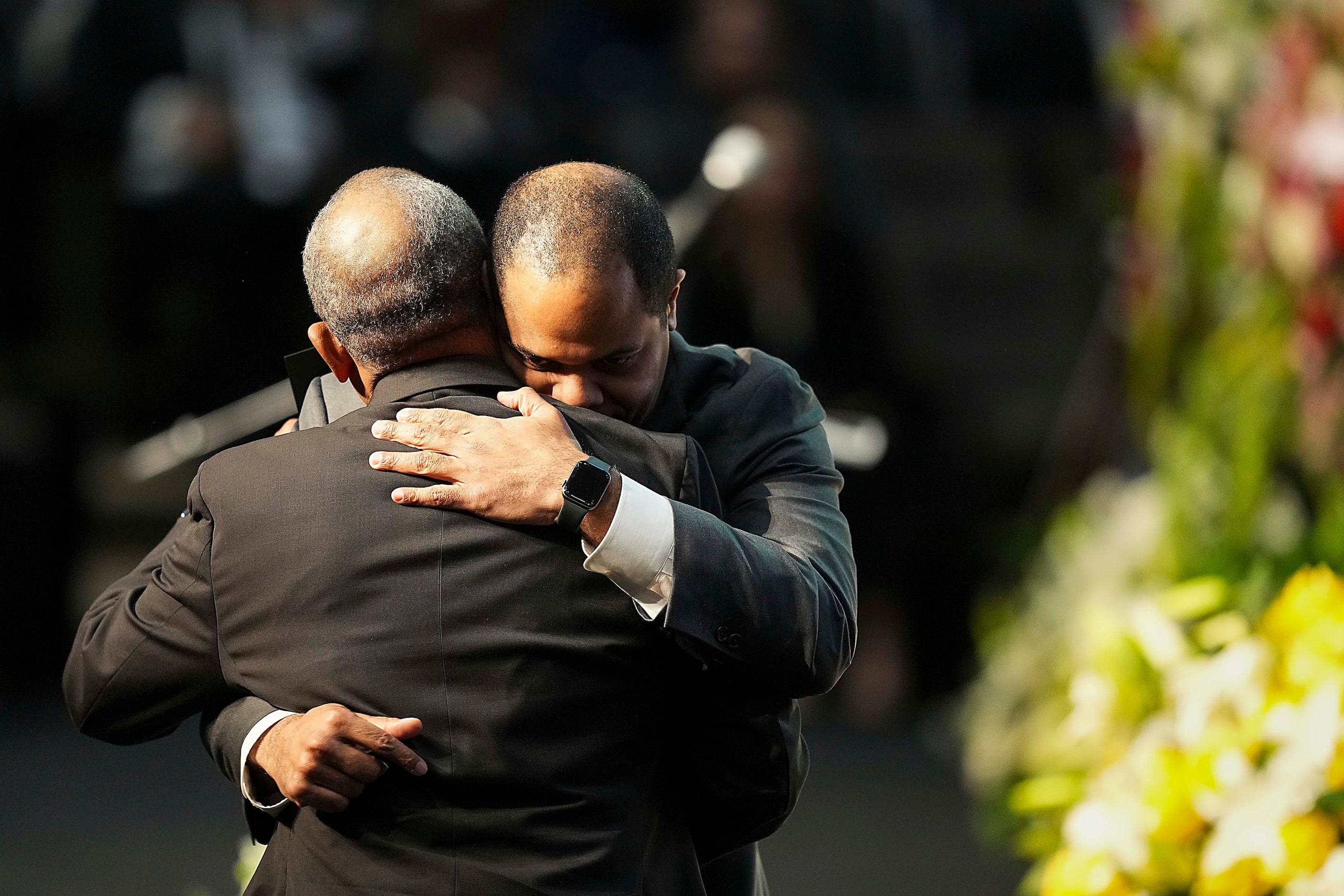 Dallas Mayor Eric Johnson hugs Kirk Johnson, son of former U.S. Rep. Eddie Bernice Johnson,...