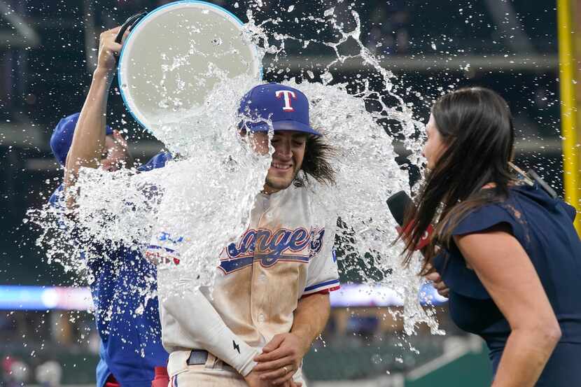 Texas Rangers Josh Smith, center, is doused by teammate Martin Perez, left, after a baseball...