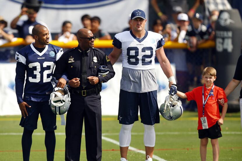 Dallas police Chief David Brown (second from left) walked arm-in-arm with Dallas Cowboys...