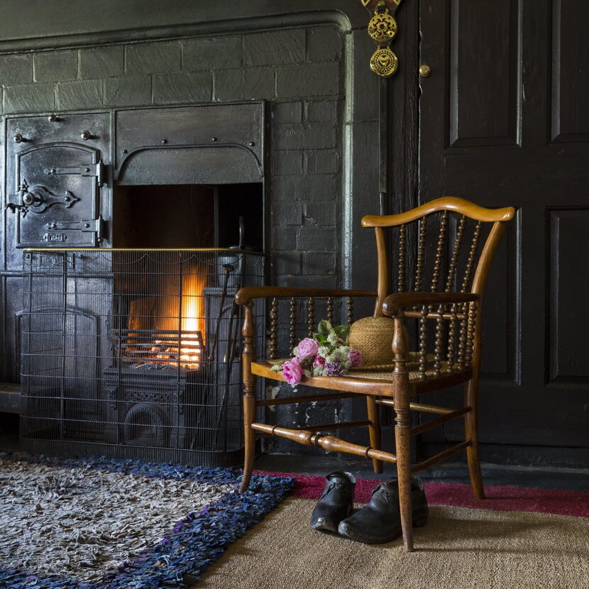 The range in the Entrance Hall at Hill Top, Cumbria with Beatrix Potter's hat and clogs....