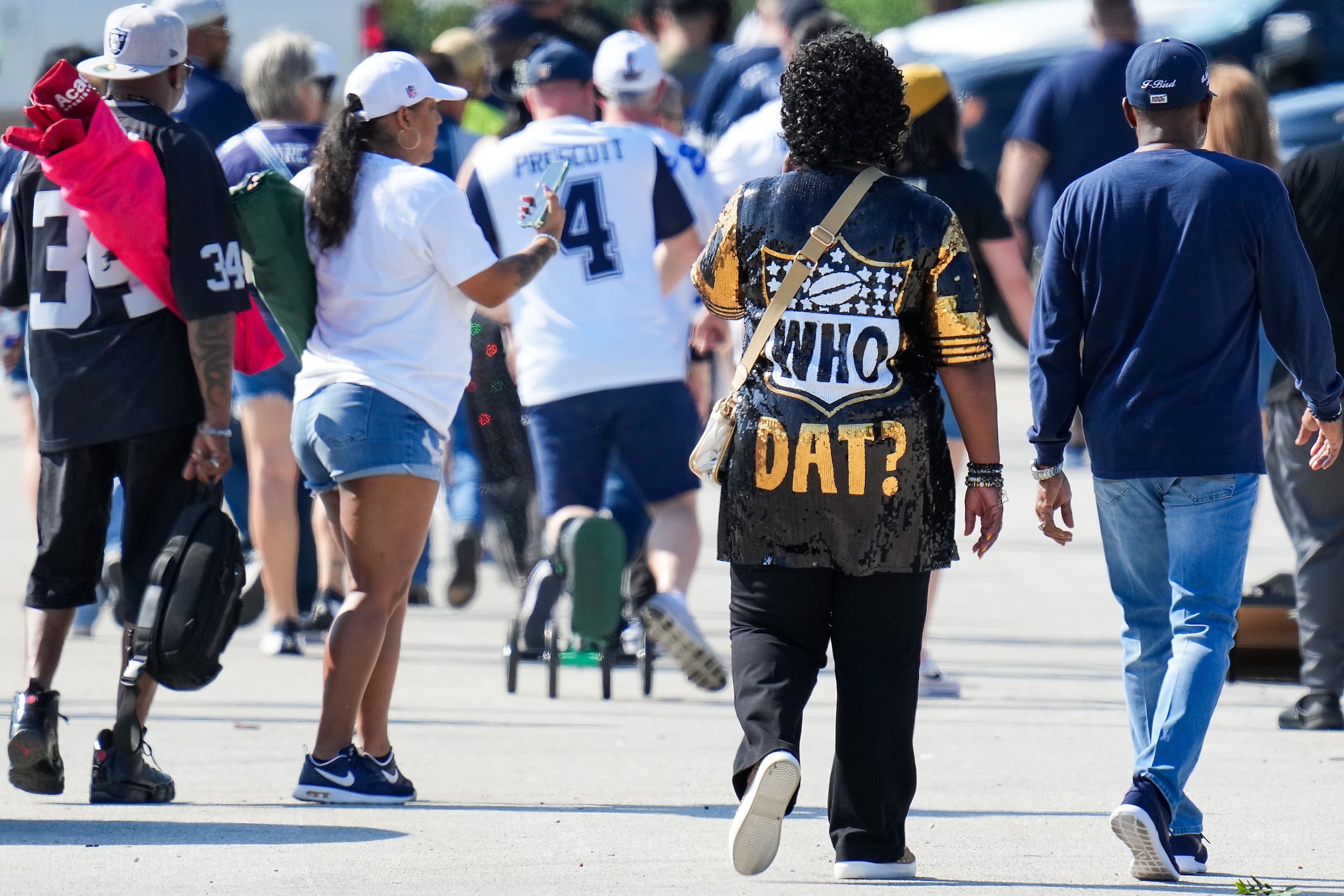 New Orleans Saints fans join Dallas Cowboys fans as they head to the stadium before an NFL...