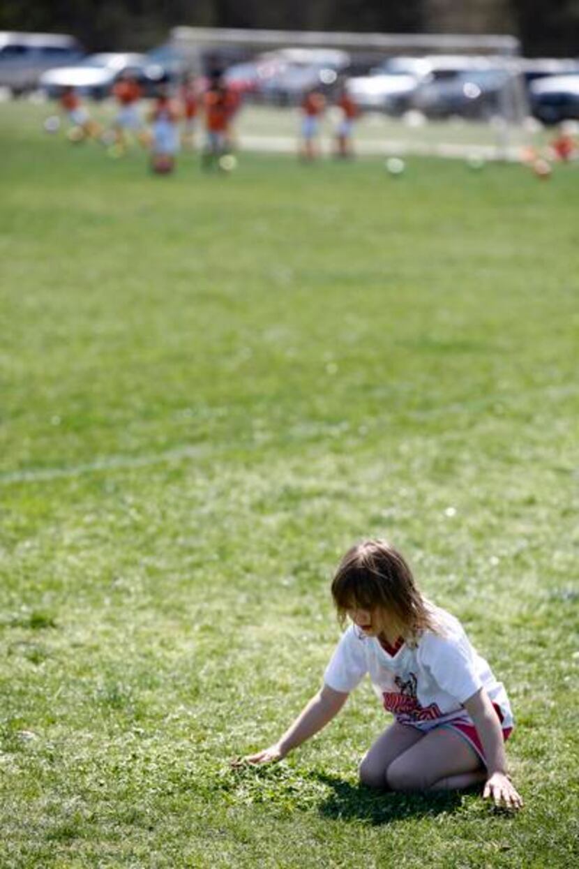 
Mary Claire Leavy, 6, plays in the grass in between soccer games at Harry Moss Park in...