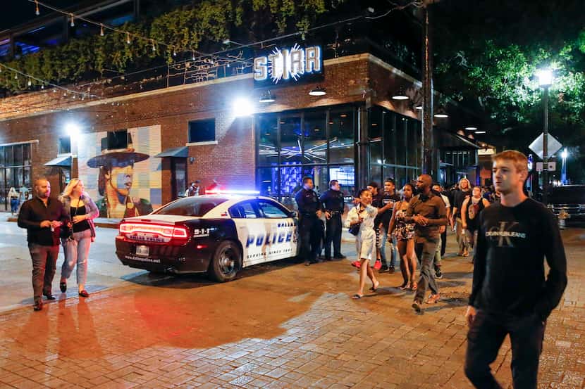 Dallas police officers stand on patrol at Crowdus and Main streets in Deep Ellum. Block...