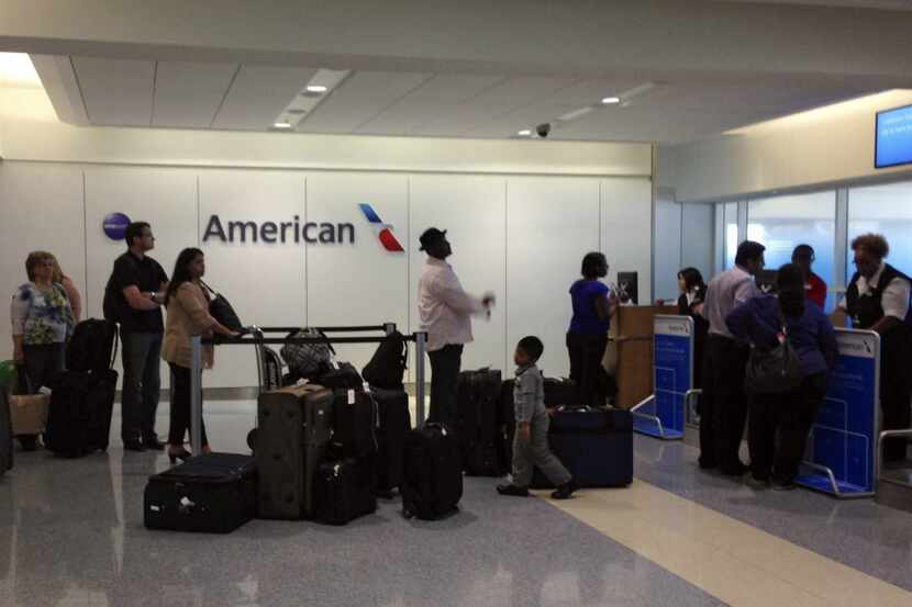 Passengers wait at an American Airlines gate at DFW Airport.