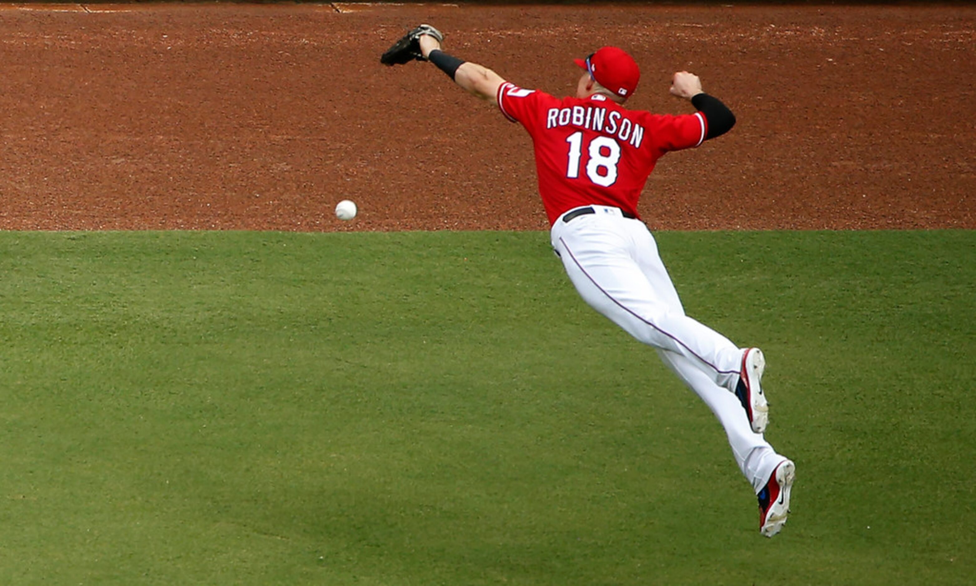 ARLINGTON, TX - AUGUST 19: Drew Robinson #18 of the Texas Rangers dives for double off the...