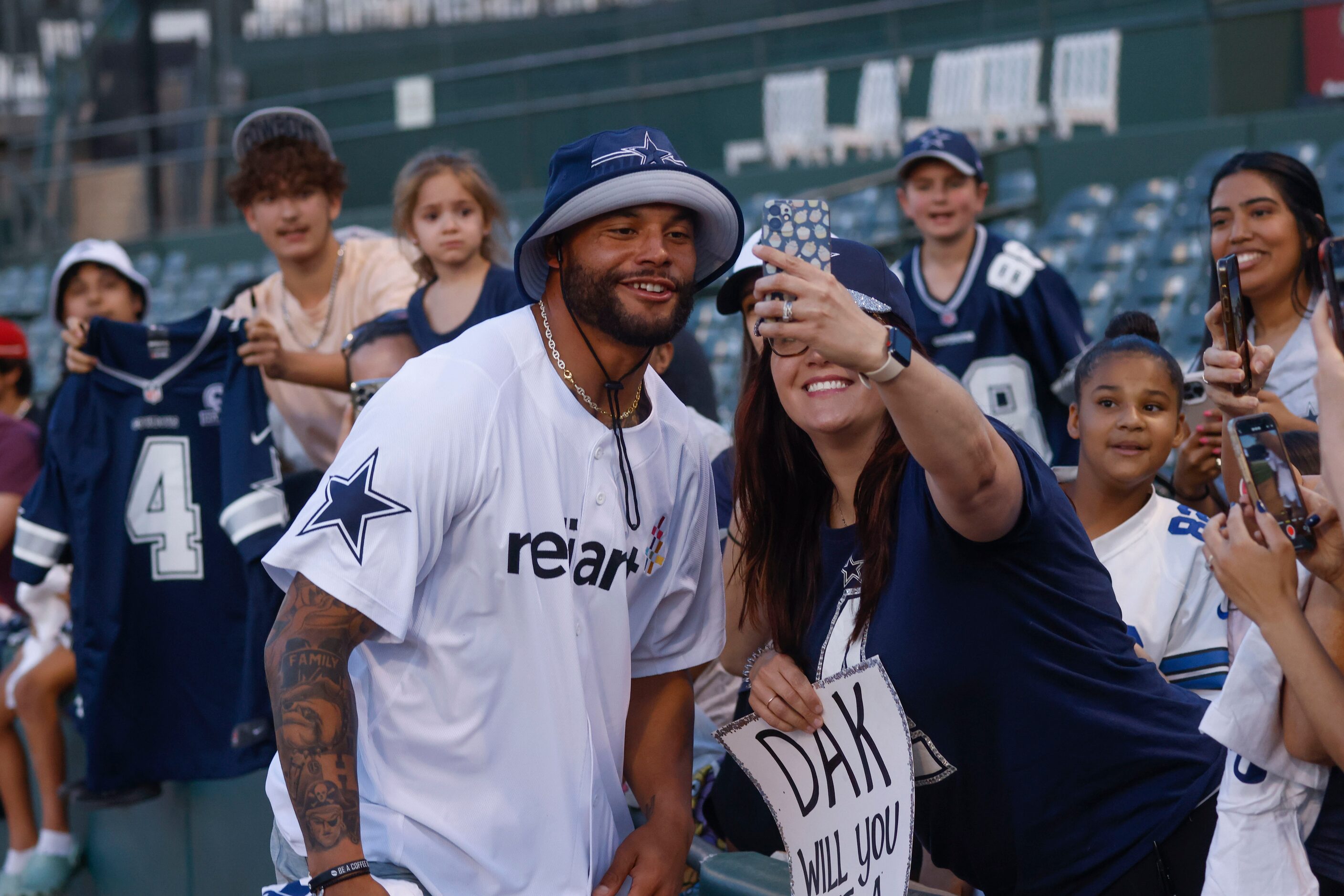 Dallas Cowboys QB Dak Prescott takes a photo with a fan during annual home run derby on...