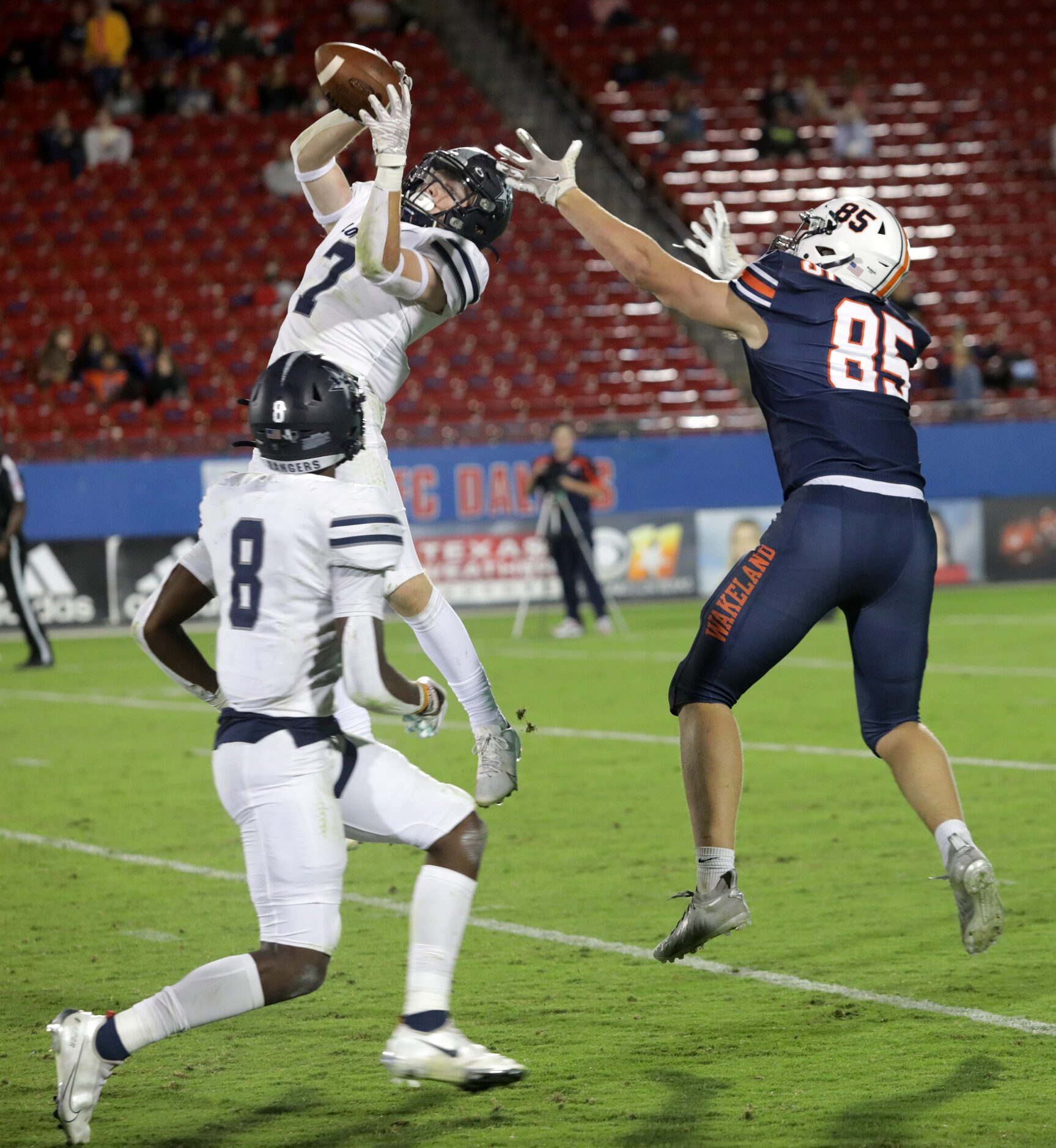 Lone Star player #7, Bennett Fryman, jumps to catch the ball and Wakeland player #85, Tripp...