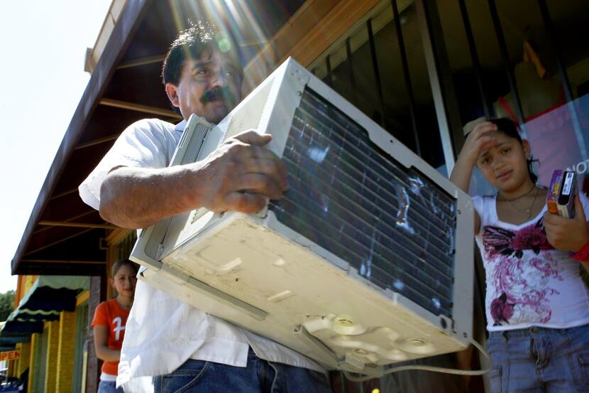 Martin Hurtado buys an air conditioner from a strip of resale shops on Jefferson Avenue in...