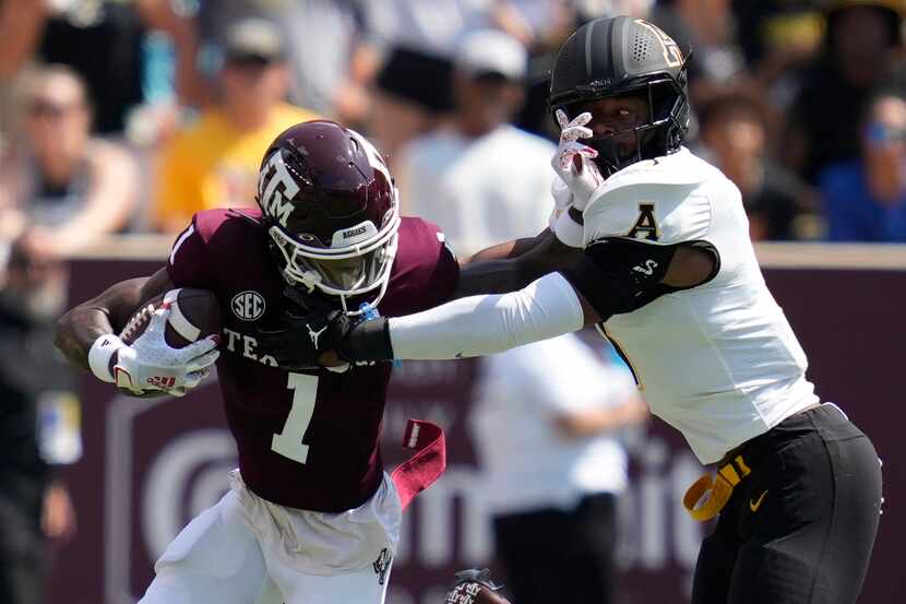 Texas A&M wide receiver Evan Stewart (1) tries to fight off a tackle by Appalachian State...