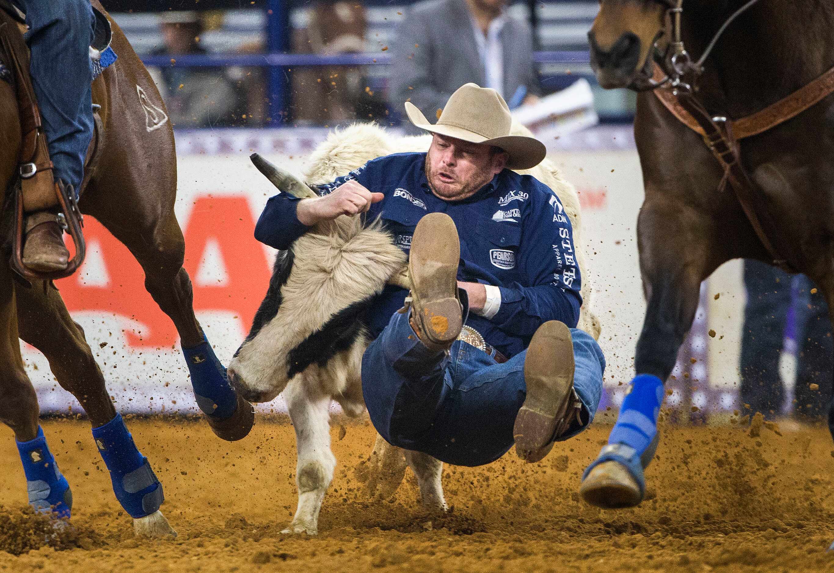 Steer wrestler Hunter Cure tackles a steer during RFD-TVÕs American Rodeo at AT&T Stadium in...