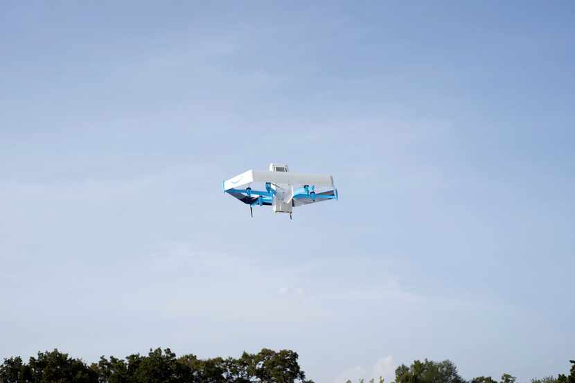 This photo provided by Amazon shows a drone delivering prescription drugs in College...