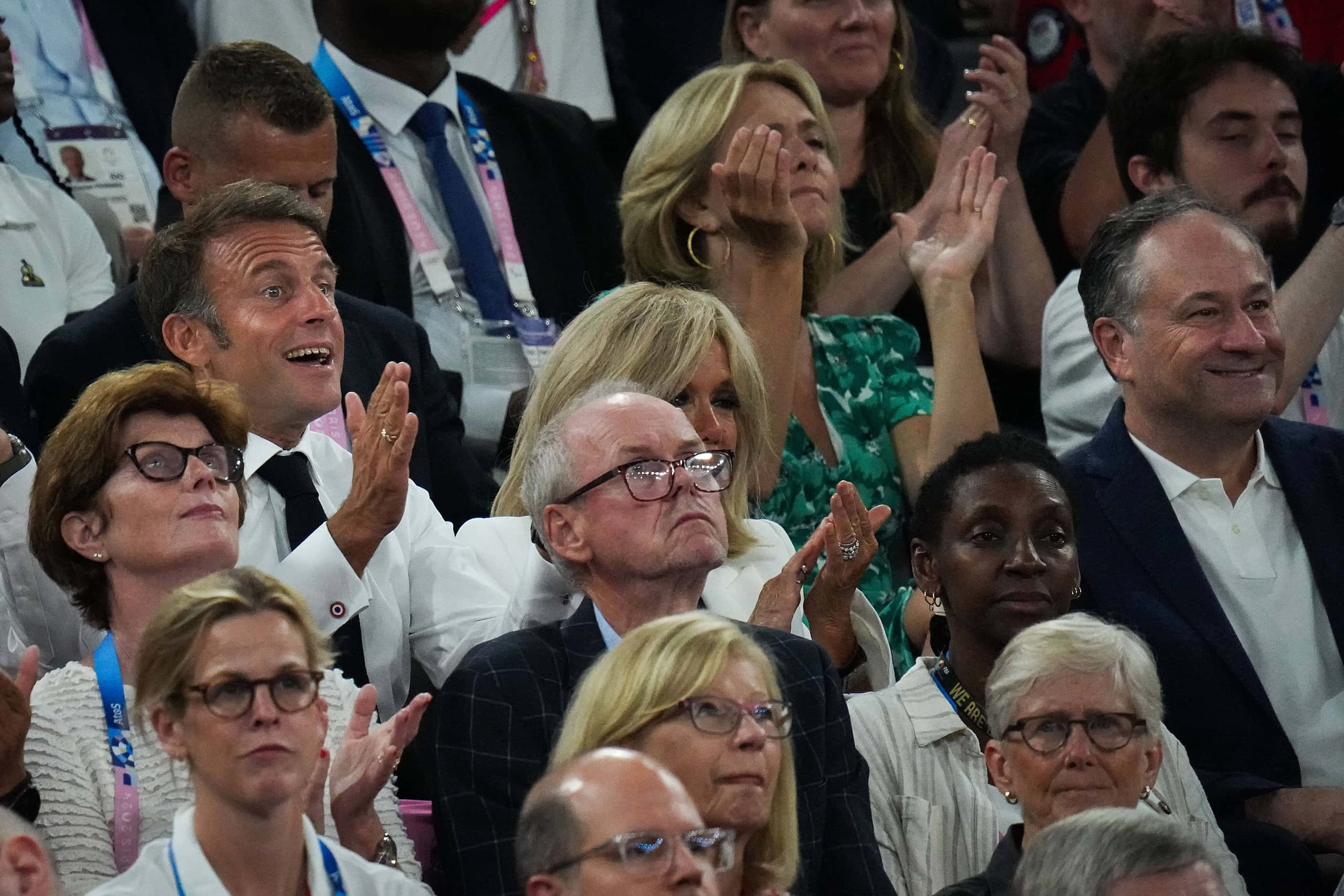 Emmanuel Macron, President of France, (left) reacts to a play while watching with US second...