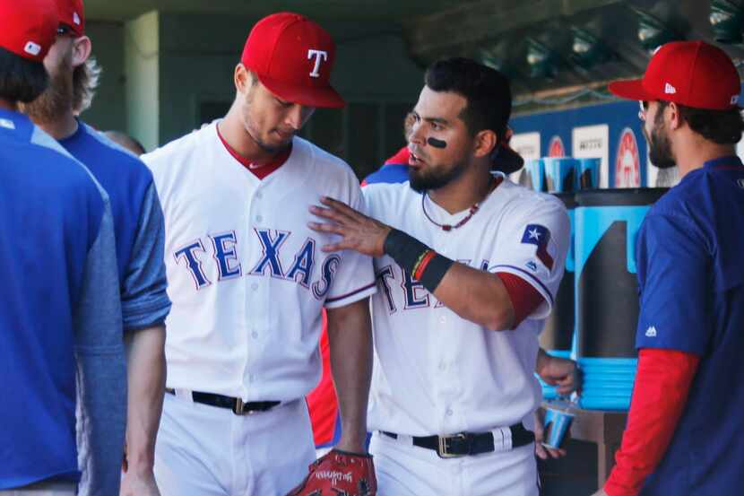 Texas Rangers catcher Robinson Chirinos (61) talks with starting pitcher Yu Darvish (11) in...