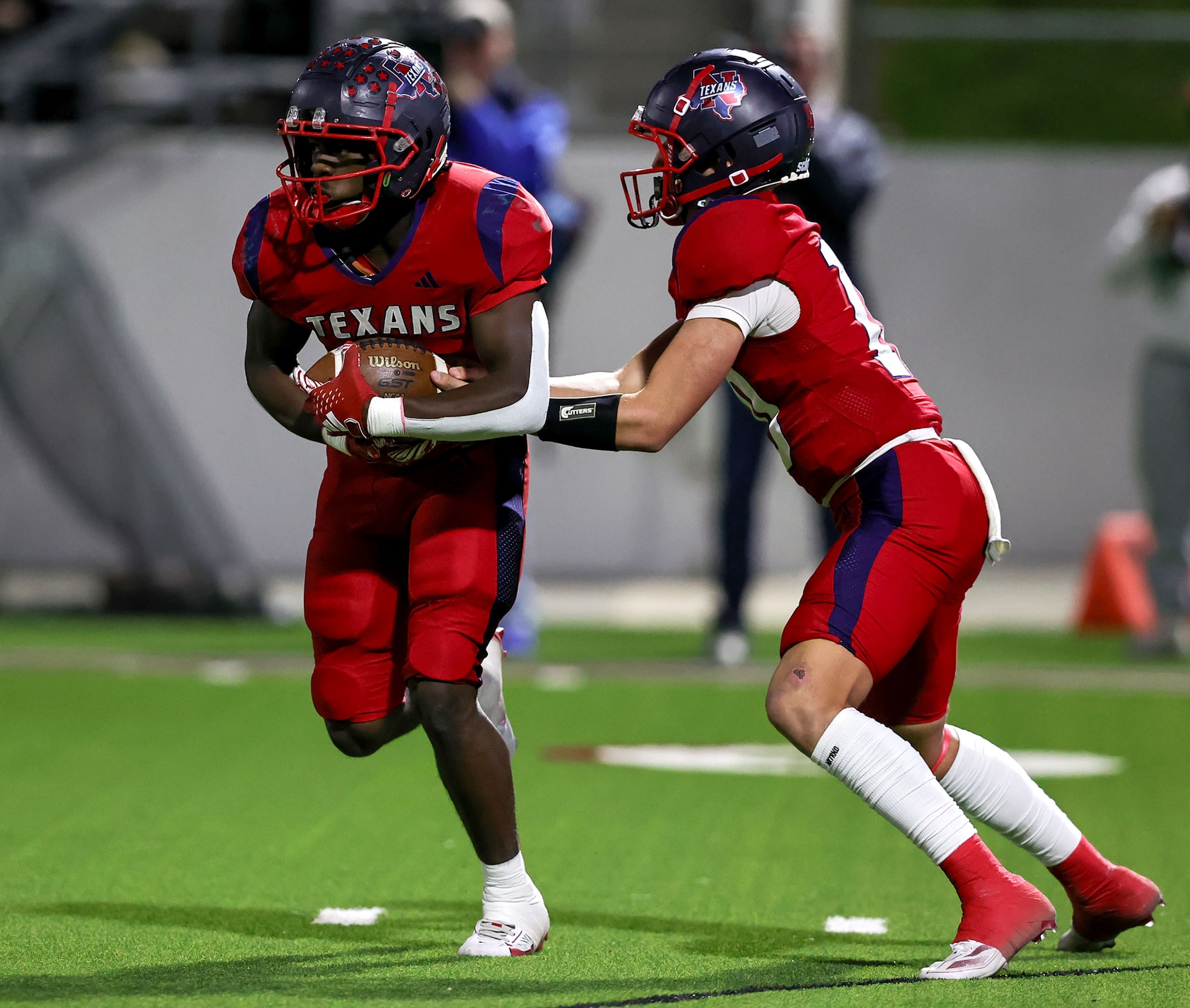 Justin Northwest quarterback Trey Poe (R) hands the ball off to running back Nate Jean (L)...