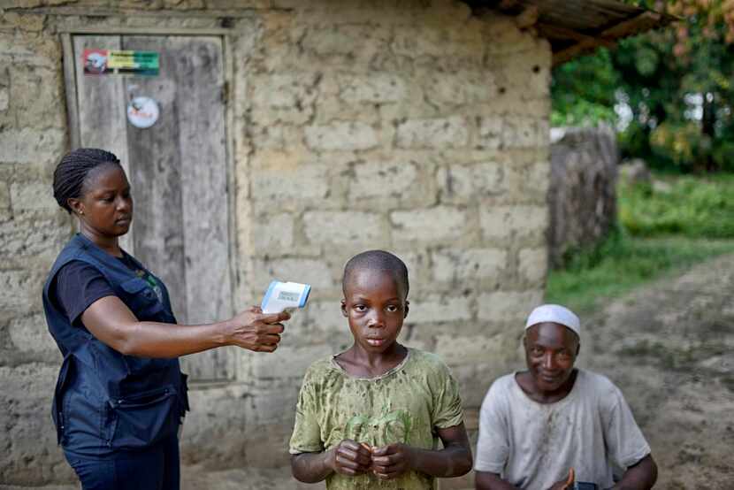 
A World Health Organization worker checks the temperature of a boy who may have been in...