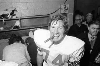 Dallas player Bob Lilly lights up a cigar in the dressing room following Super Bowl victory...