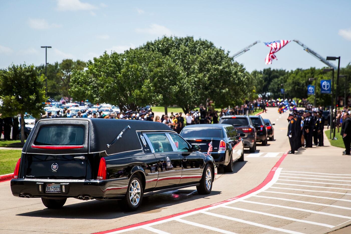 The hearse carrying Dallas police Sr. Cpl. Lorne Ahrens departs Prestonwood Baptist Church...