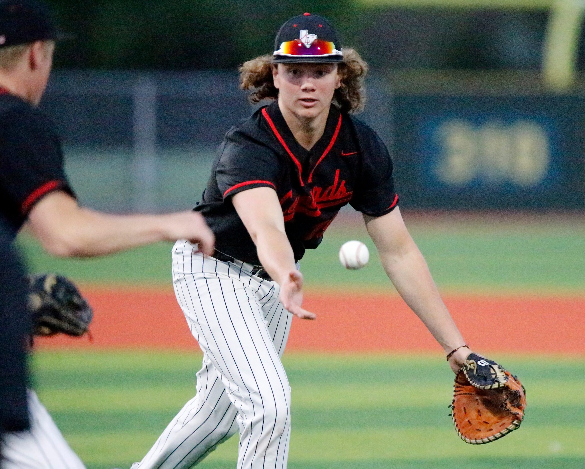 Lovejoy High School first baseman Will Branum (19) tosses the ball to the pitcher covering...