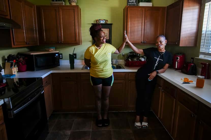 Temeckia Derrough (right) laughs in the kitchen with her daughter Twantanisha Derrough while...