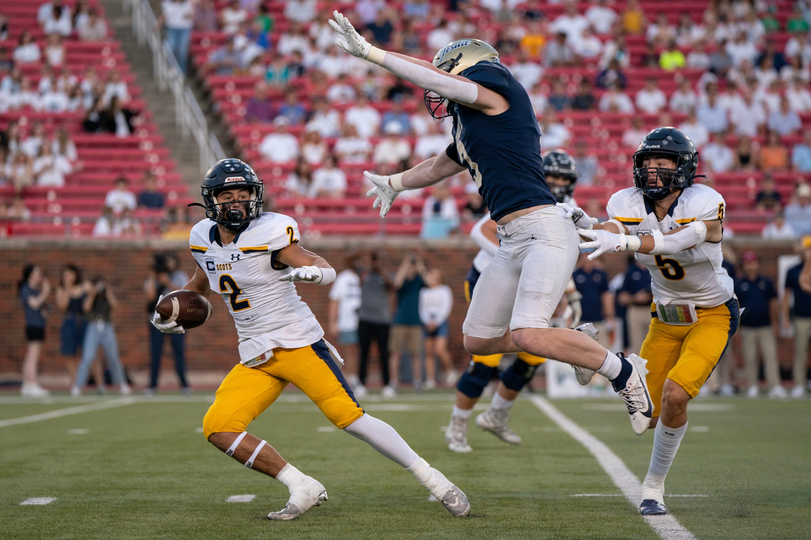 Highland Park senior running back Wilson Axley (2) tries to avoid Jesuit junior defensive...