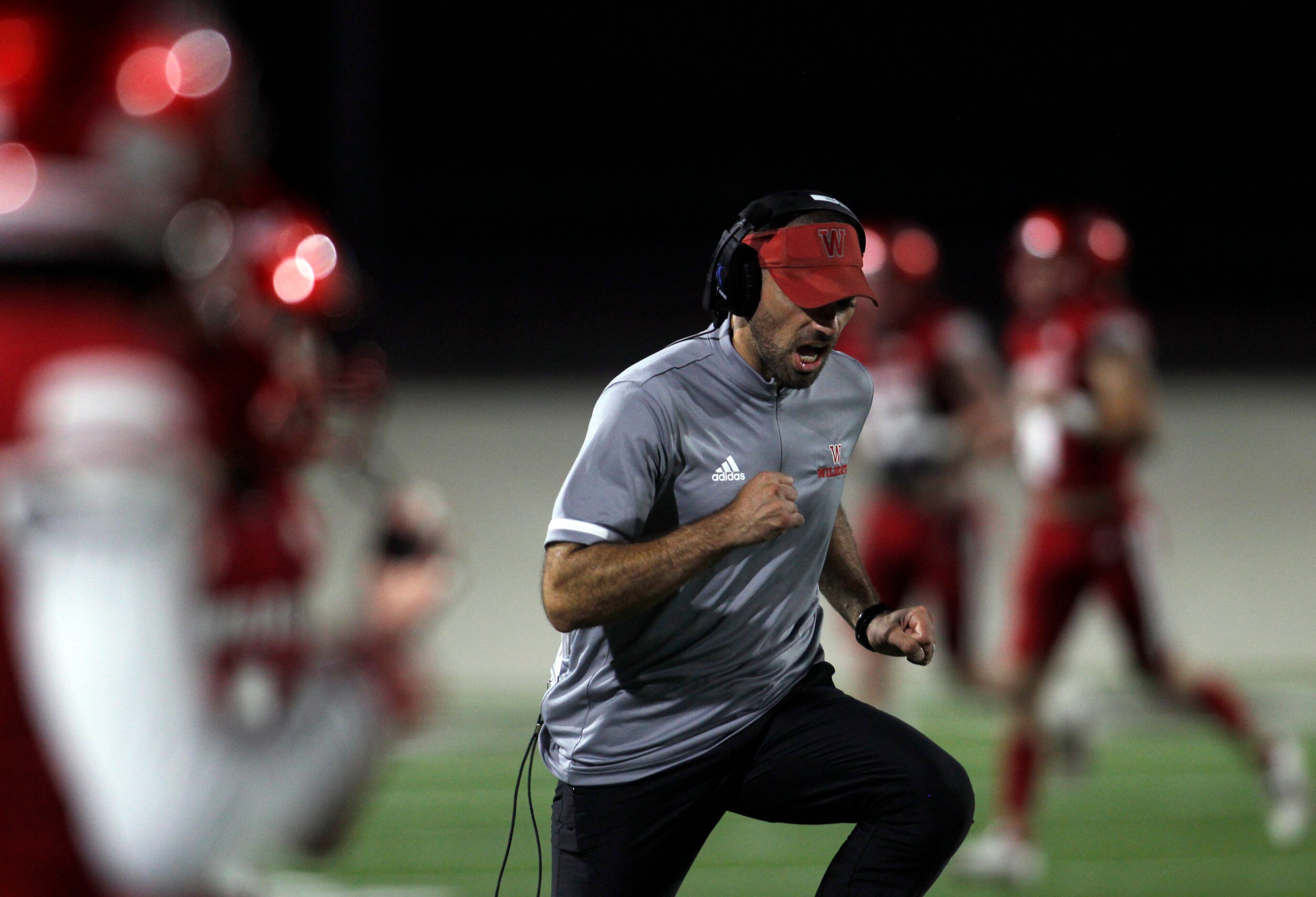 Dallas Woodrow Wilson head coach Tony Benedetto hustles along the` team bench area following...