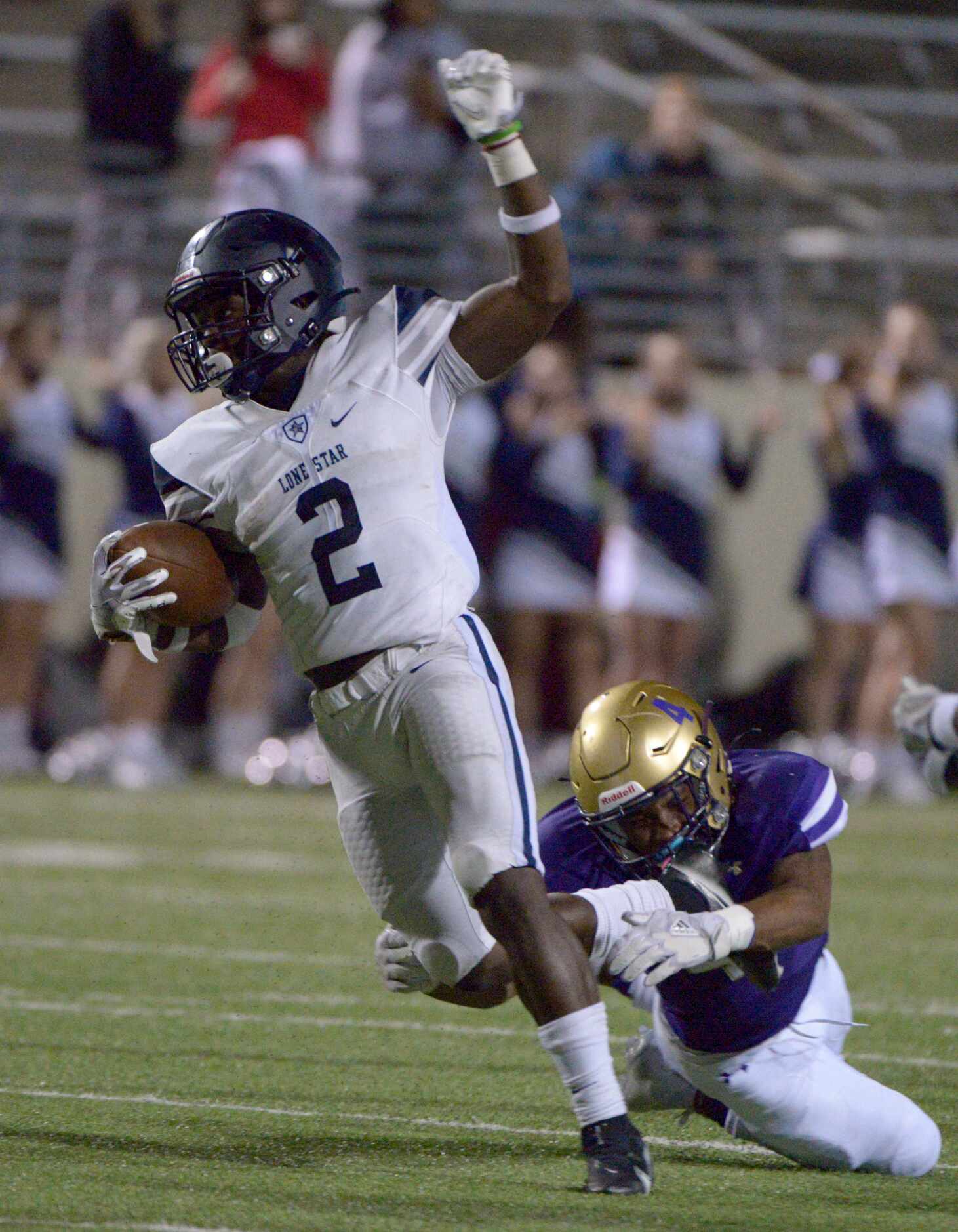Lone Star’s Ashton Jeanty (2) runs through a tackle attempt by Denton’s Deonte Cates (4) in...
