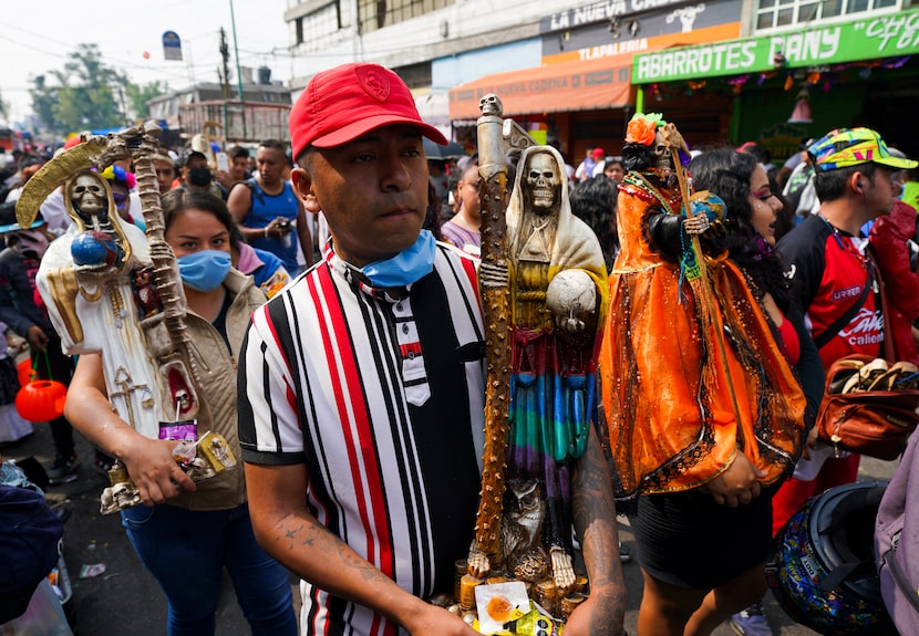 Devotos cargan estatuas ornamentadas de "La Santa Muerte", en el barrio de Tepito de la...