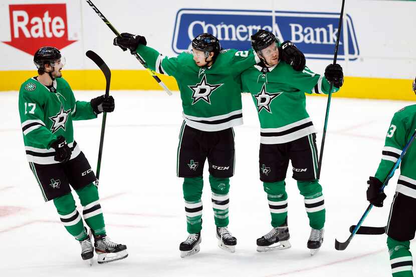 Dallas Stars left wing Jason Robertson (21) is congratulated by his teammates after scoring...