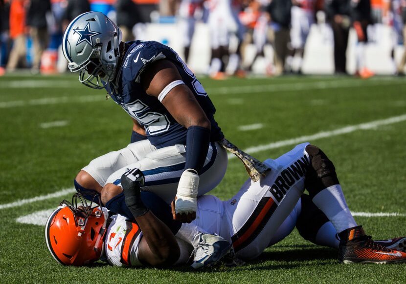 Cowboys defensive tackle David Irving (95) sits on the chest of Cleveland Browns center...