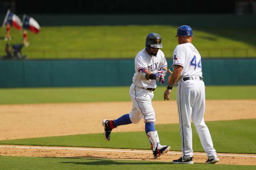 Texas Rangers second baseman Rougned Odor (left) is congratulated by third base coach Tony...