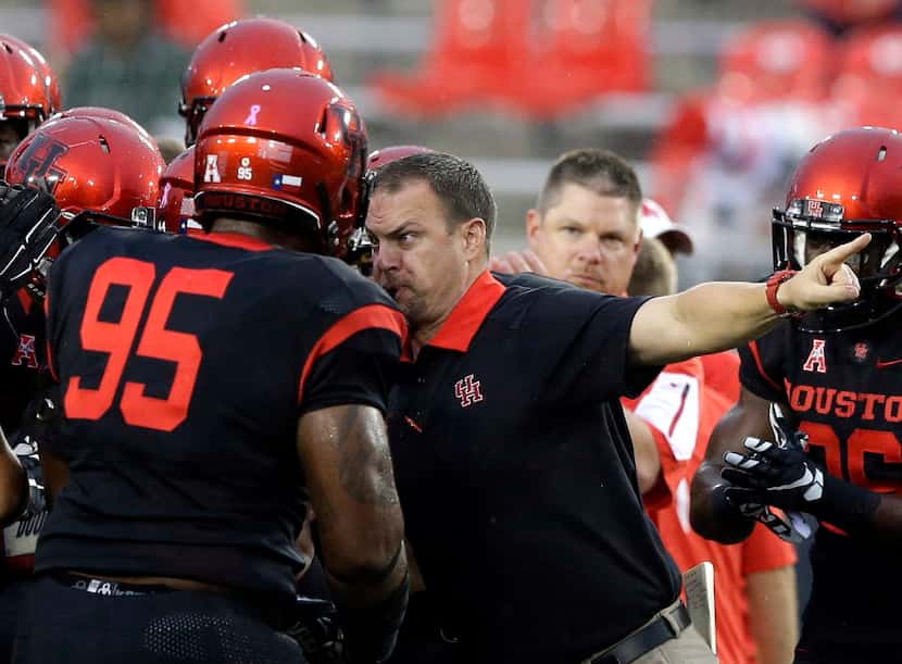 In this Oct. 31, 2015, file photo, Houston head coach Tom Herman, center, revs up his...