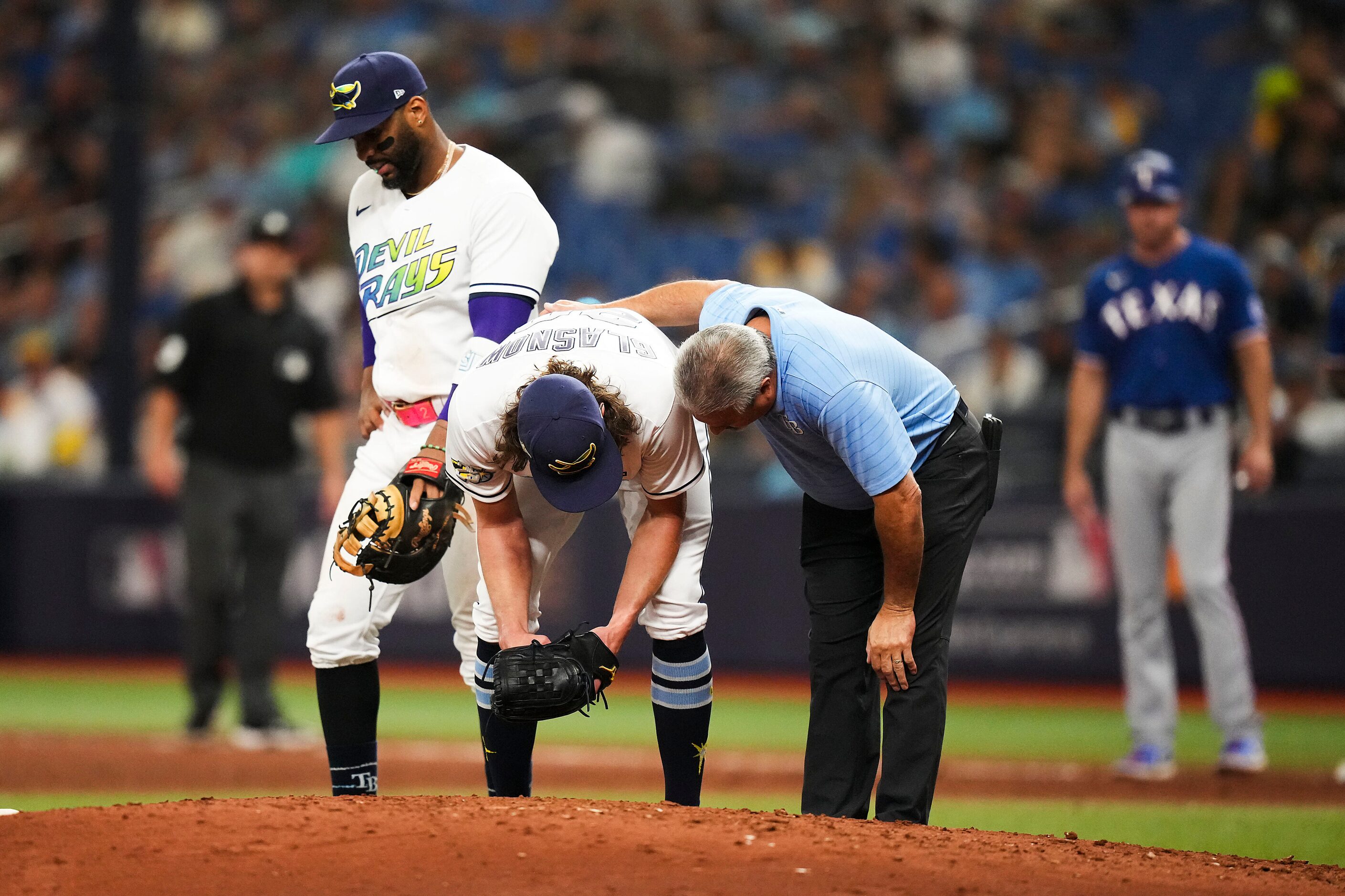 Tampa Bay Rays starting pitcher Tyler Glasnow receives attention after being hit by a line...