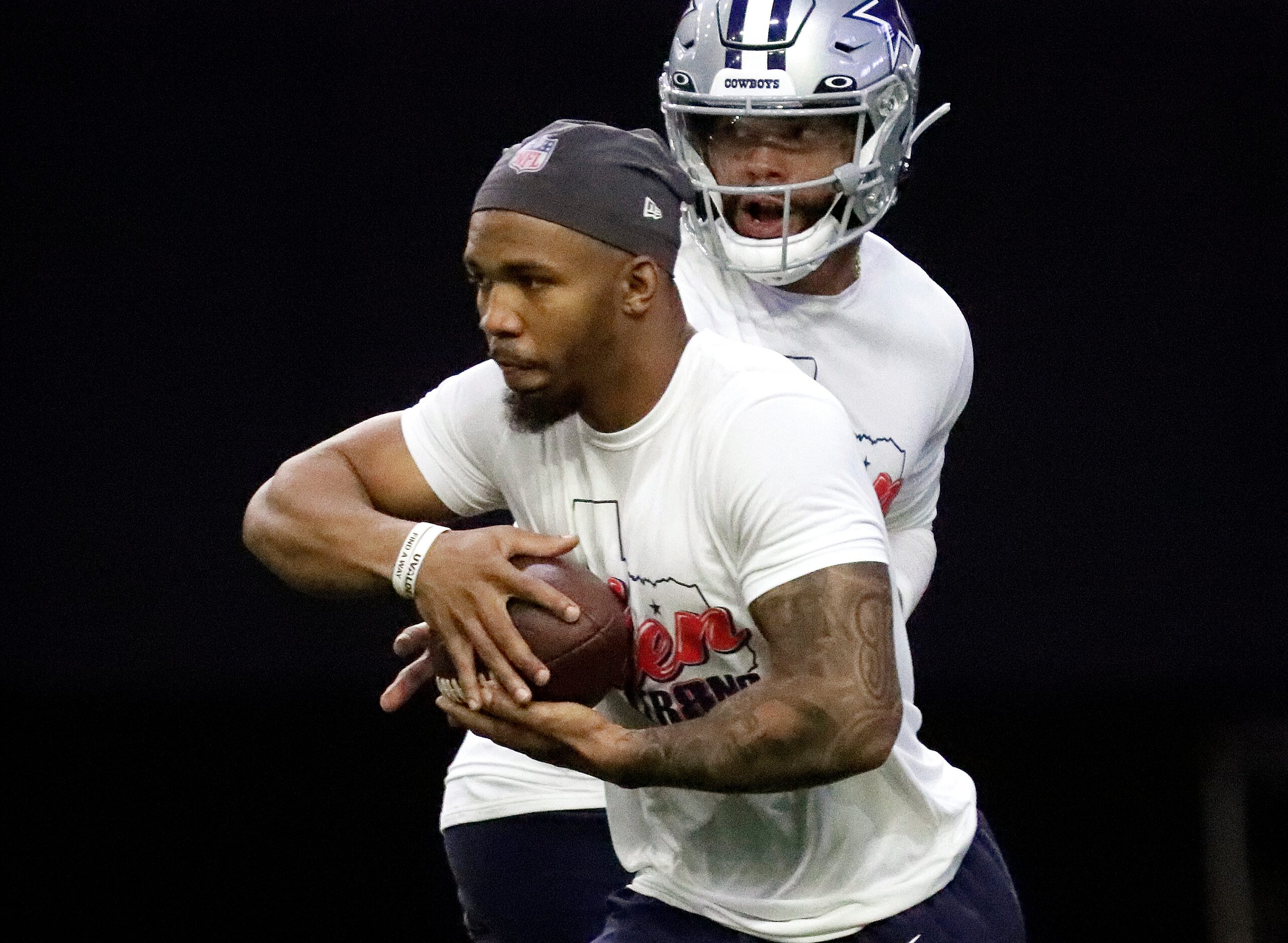 Running back Tony Pollard takes a handoff from quarterback Dak Prescott as the Dallas...