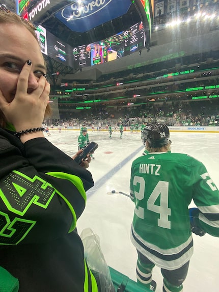 Linnea Sirén at a Dallas Stars game standing behind Stars forward Roope Hintz.