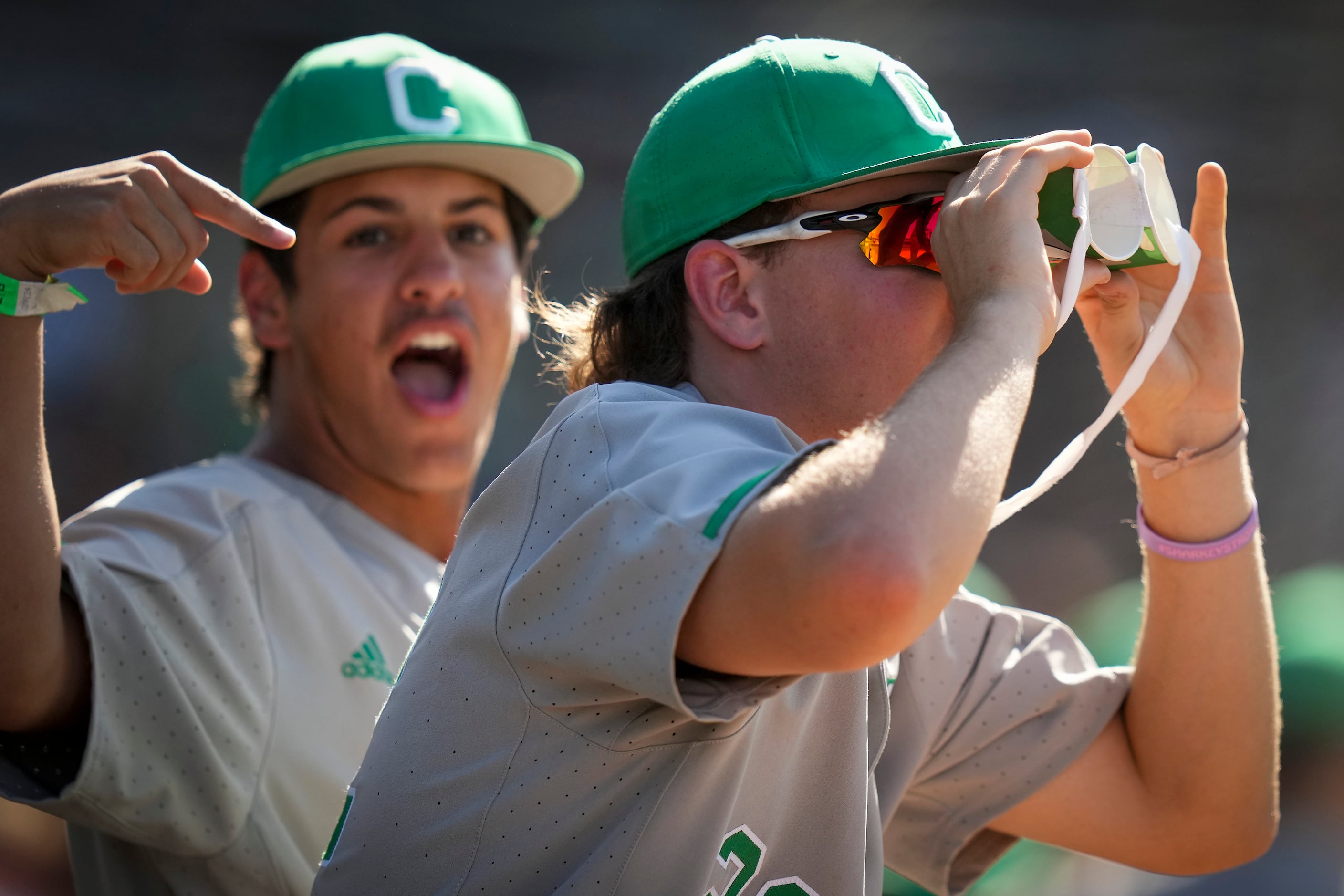 Southlake Carroll outfielder Eric Thiel (22) uses two cups taped together to mimic...