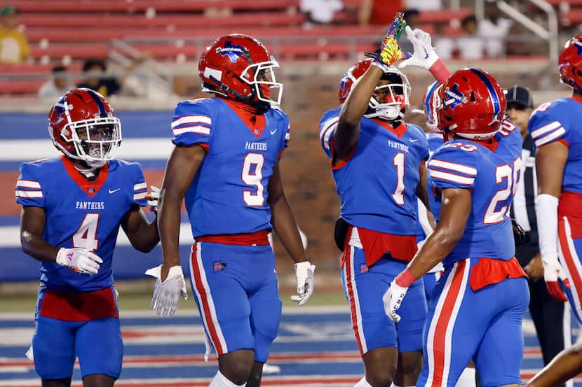Duncanville wide receiver Dakorien Moore (1) is congratulated on his first quarter touchdown...