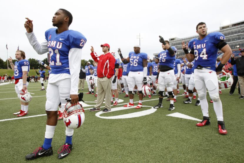 SMU defensive back Kenneth Acker (21)and defensive end Beau Barnes (94) participate in a...