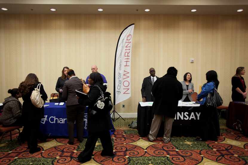 Job seekers spoke to representatives from Charter Communications (left) and Cinsay Inc....