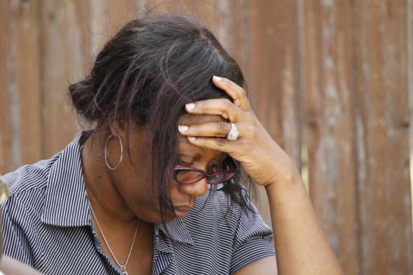 Sonya Ellington, a family friend of Zina Bowser, sat on a lawn near Bowser's house in DeSoto...