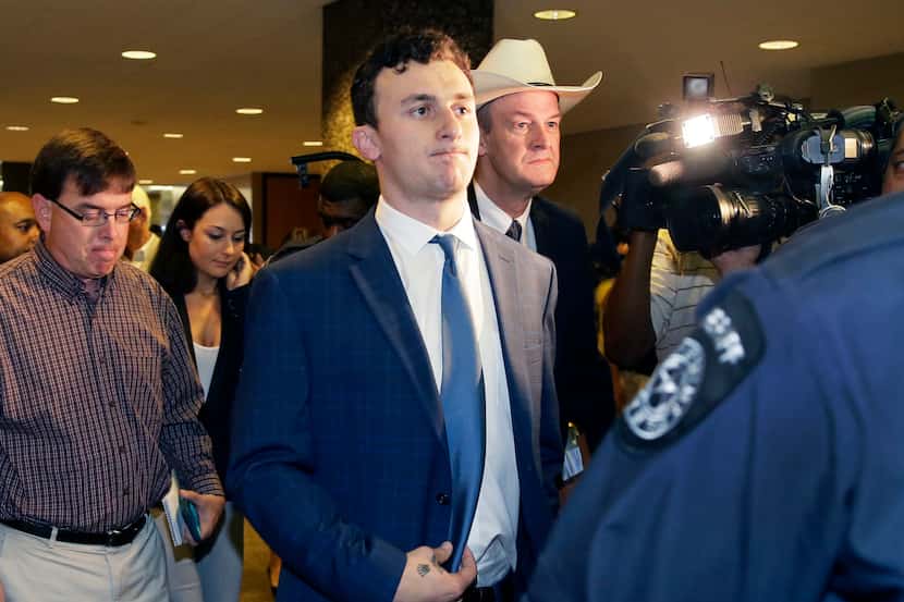 Former Cleveland Browns quarterback Johnny Manziel walks with his lawyer Jim Darnell, right,...