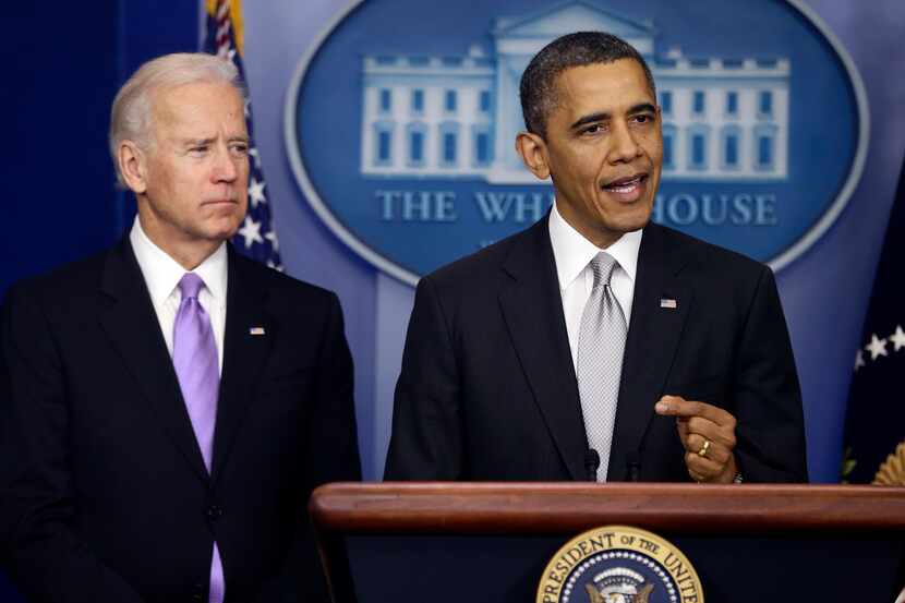 President Barack Obama stands with Vice President Joe Biden as he makes a statement...