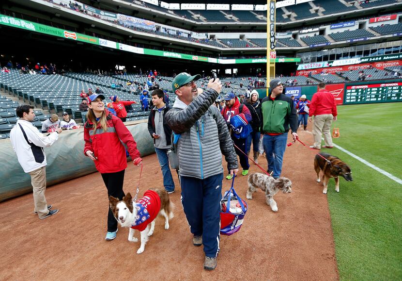 People walk on the ground with their dogs during the annual Bark in the Park night at the...