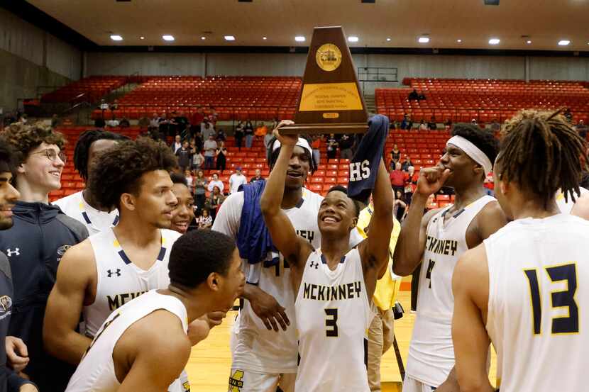 McKinney’s Jacovey Campbell (3) holds the championship trophy after defeating Arlington...