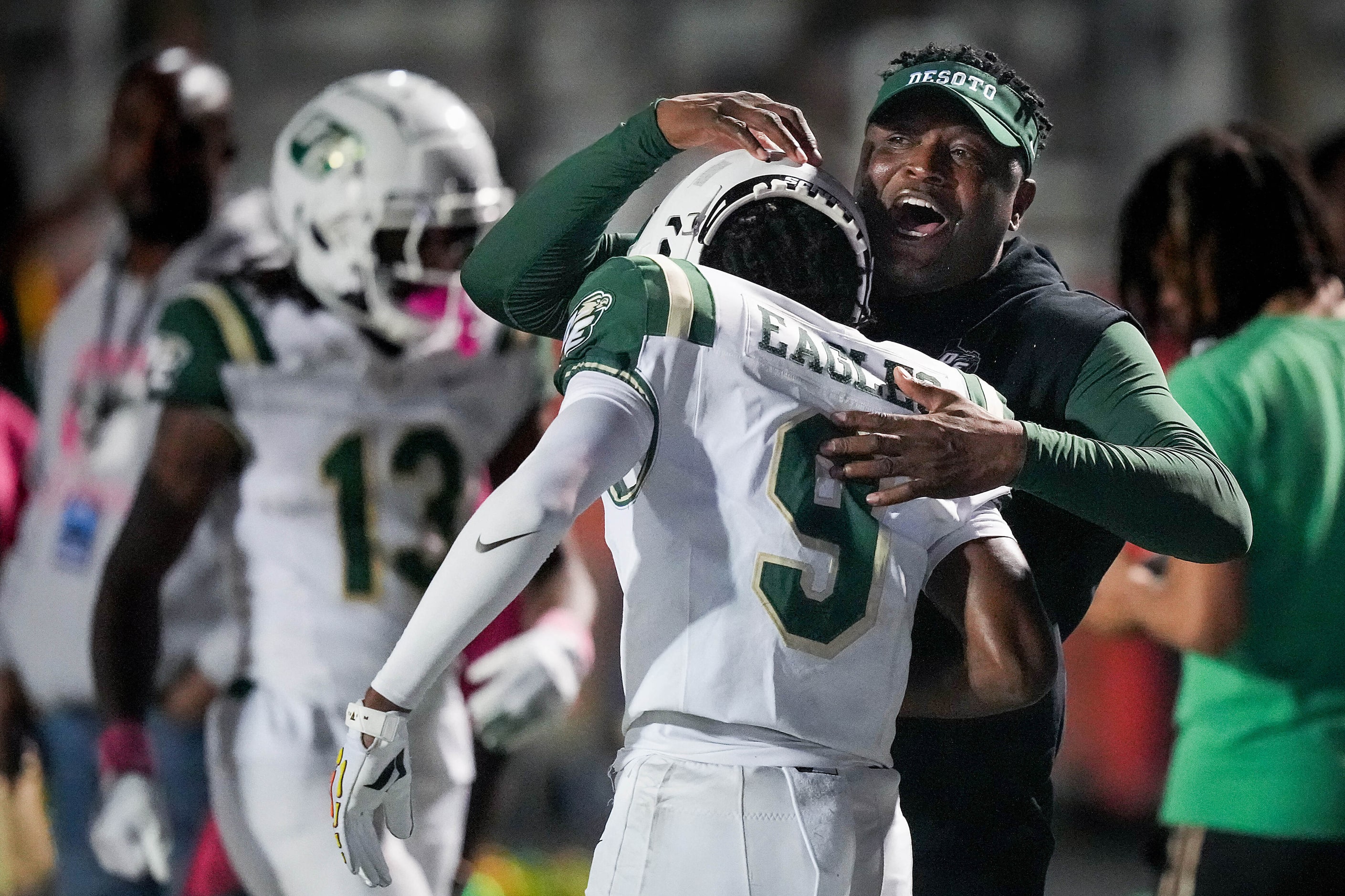 DeSoto head coach Claude Mathis celebrates with DeSoto wide receiver Kristoff Fantroy (9)...