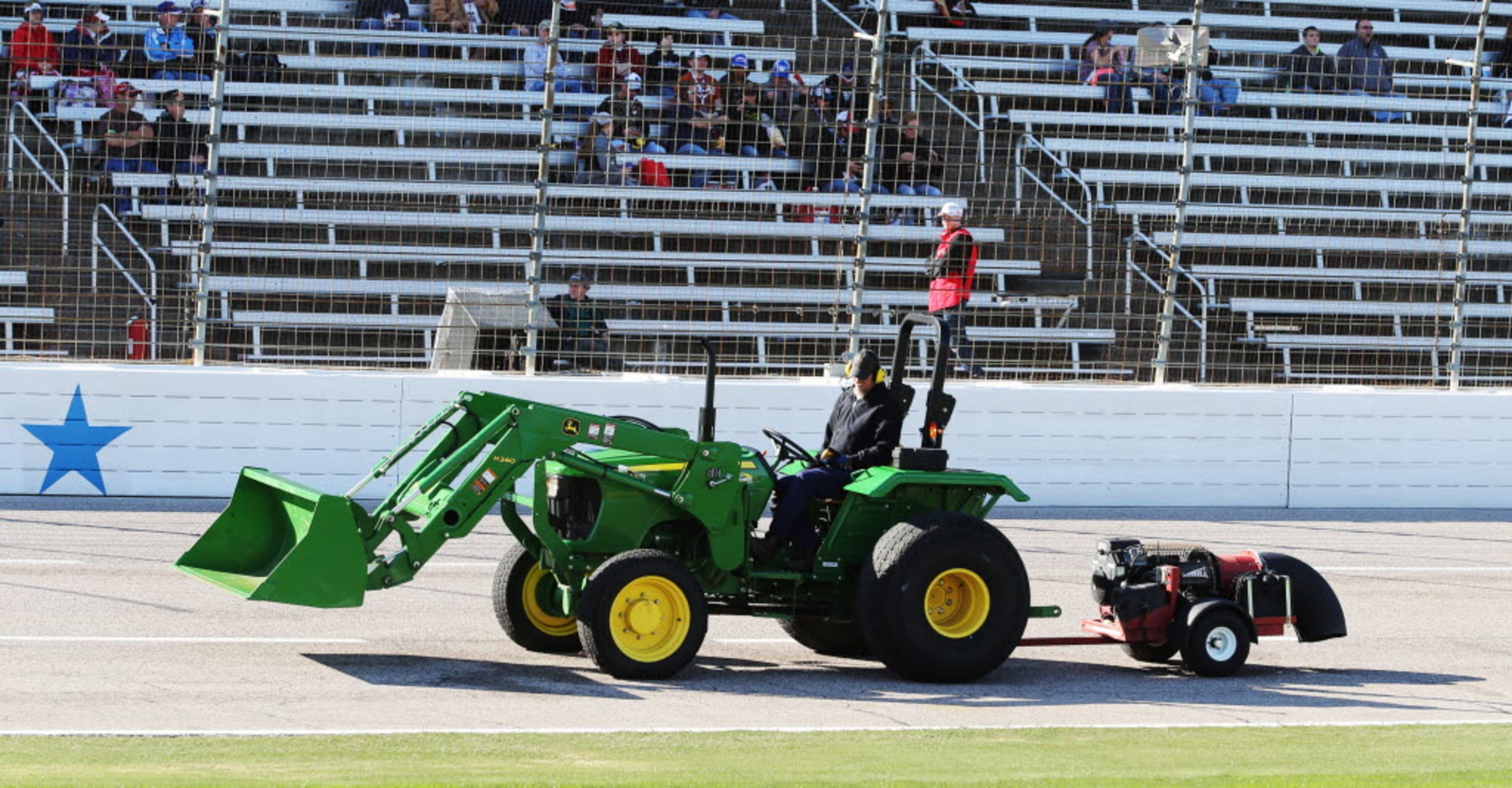 A John Deere hauls a blower used to dry the track before the start of the NASCAR XFINITY...