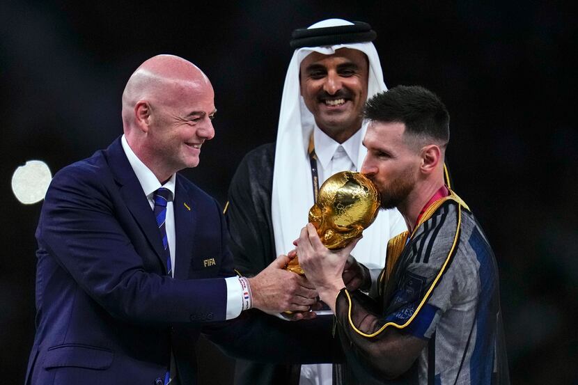 Argentina's Lionel Messi kisses the trophy presented by FIFA President Gianni Infantino,...