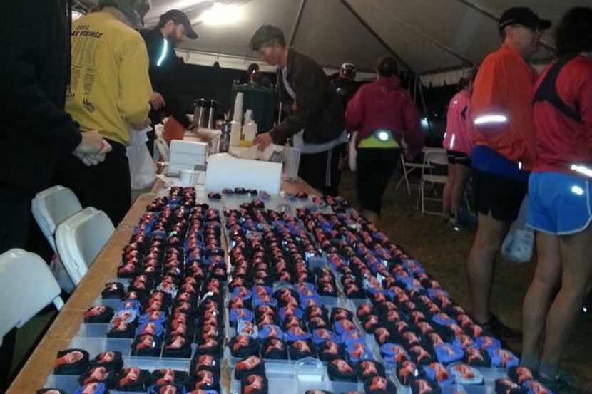 Volunteers help runners get timing chips, bibs, drinks and a snack in the pre-dawn hours...