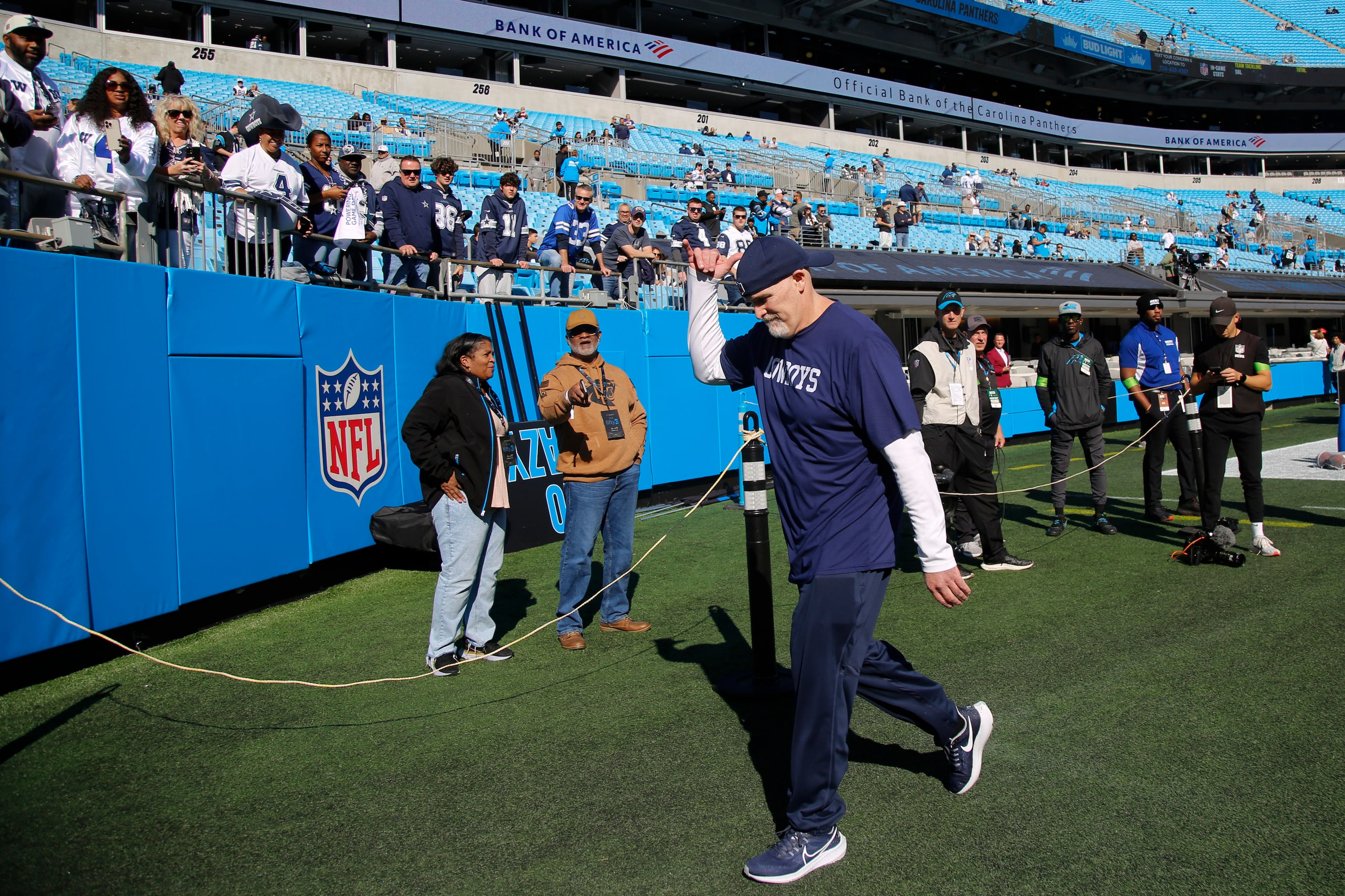 Dallas Cowboys defensive coordinator Dan Quinn motions to fans before an NFL game against...